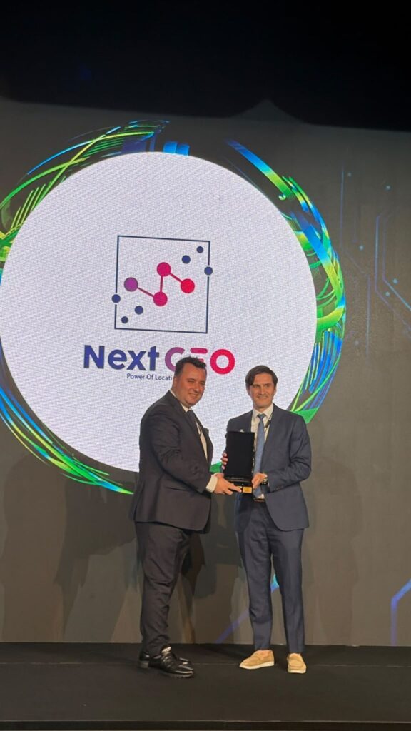The award presentation on stage at the Deloitte Technology Fast 50 Türkiye 2026 ceremony, with the Next GEO logo on the screen behind.
