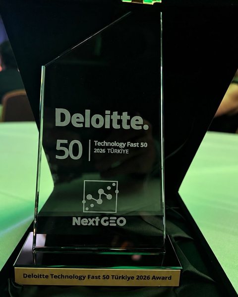 Next Geo’ya verilen Deloitte Technology Fast 50 Türkiye 2026 ödülü: Deloitte, Technology Fast 50 2026 Türkiye ve Next GEO logosu kazınmış cam plaket, altında ödülün adının yazılı olduğu levha.